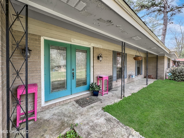 view of exterior entry with a yard