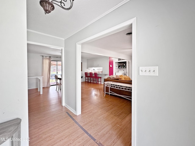 hallway with ornamental molding and hardwood / wood-style floors