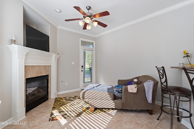 tiled living room featuring ceiling fan, ornamental molding, and a tile fireplace