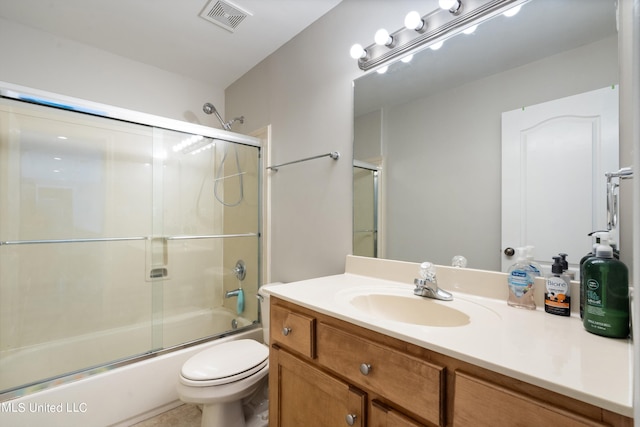 full bathroom featuring vanity, bath / shower combo with glass door, and toilet