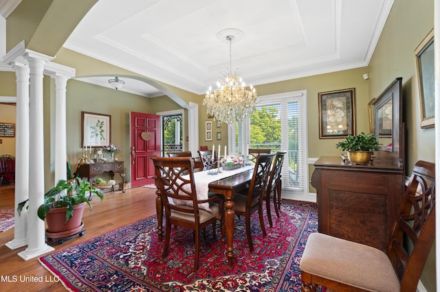 9194 Rosalie Cv, Olive Branch, MS 38654 - dining room featuring healthy amount of natural light, a tray ceiling, wood finished floors, arched walkways, and ornamental molding