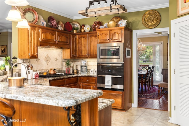 9194 Rosalie Cv, Olive Branch, MS 38654 - kitchen featuring stainless steel appliances, crown molding, brown cabinets, a peninsula, and decorative backsplash