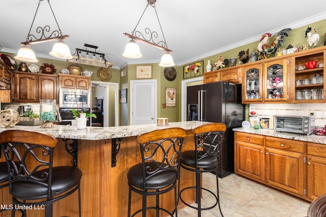 9194 Rosalie Cv, Olive Branch, MS 38654 - kitchen featuring appliances with stainless steel finishes, decorative backsplash, a kitchen breakfast bar, crown molding, and light tile patterned floors