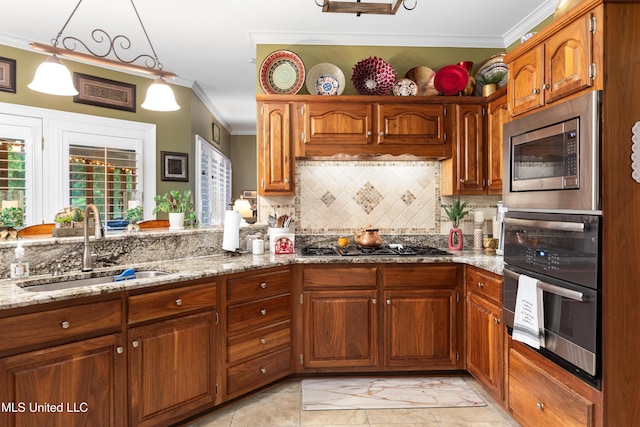 9194 Rosalie Cv, Olive Branch, MS 38654 - kitchen featuring appliances with stainless steel finishes, crown molding, backsplash, light stone countertops, and brown cabinetry