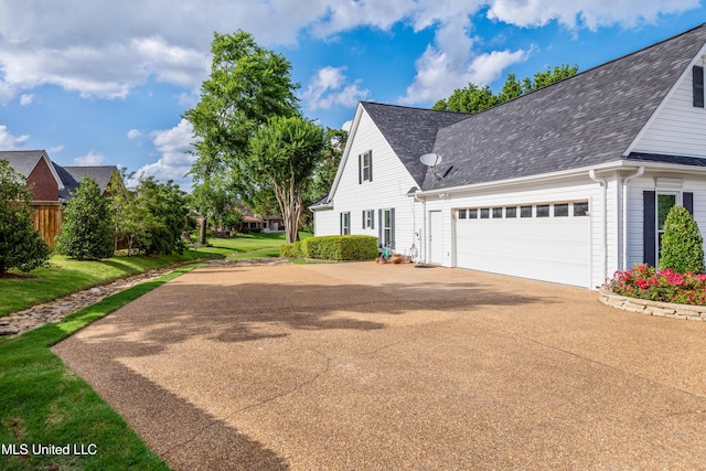 9194 Rosalie Cv, Olive Branch, MS 38654 - view of side of property with driveway, a shingled roof, and an attached garage