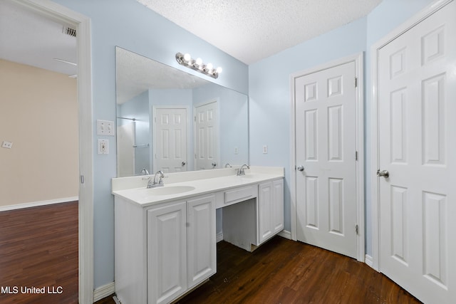 bathroom featuring vanity, a textured ceiling, and hardwood / wood-style flooring