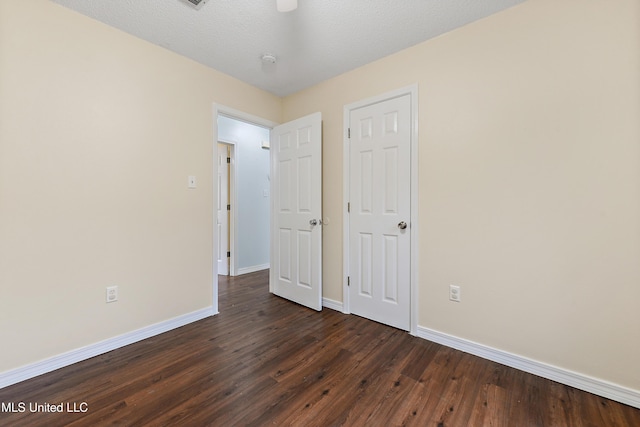 unfurnished bedroom with dark hardwood / wood-style flooring and a textured ceiling