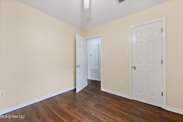 unfurnished bedroom with dark hardwood / wood-style floors and a textured ceiling