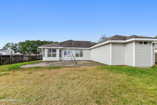 rear view of house featuring a patio and a lawn