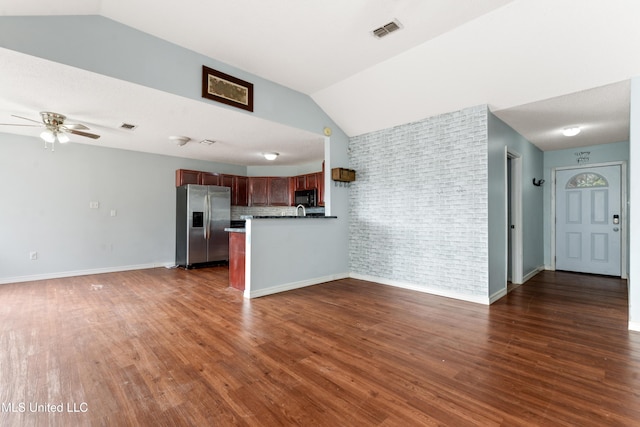 unfurnished living room featuring lofted ceiling, ceiling fan, and dark wood-type flooring