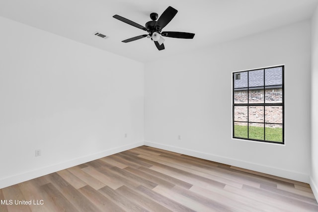 empty room with visible vents, ceiling fan, baseboards, and light wood-style floors