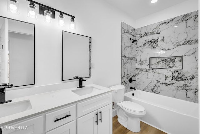 bathroom featuring shower / tub combination, a sink, toilet, double vanity, and wood finished floors