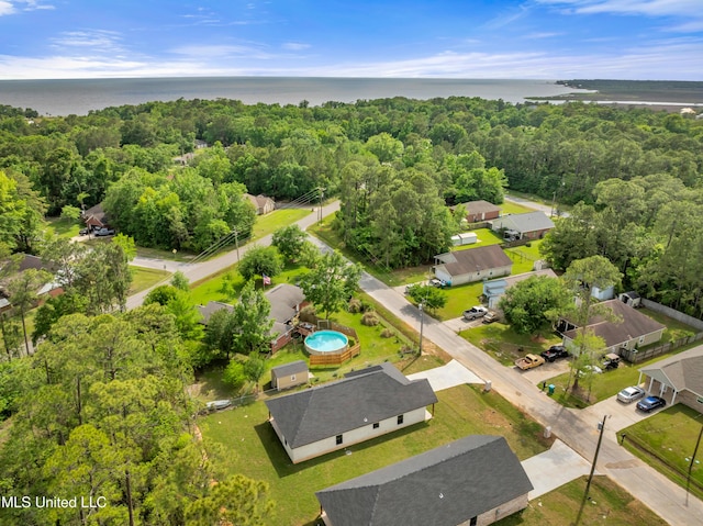 birds eye view of property featuring a wooded view and a water view