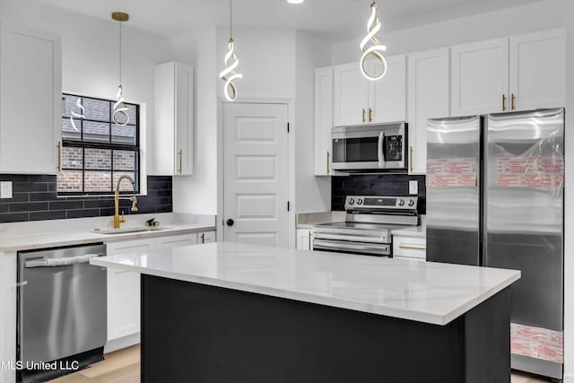 kitchen with white cabinetry, tasteful backsplash, appliances with stainless steel finishes, and a sink