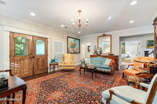 living room with ornamental molding, a chandelier, and dark hardwood / wood-style floors