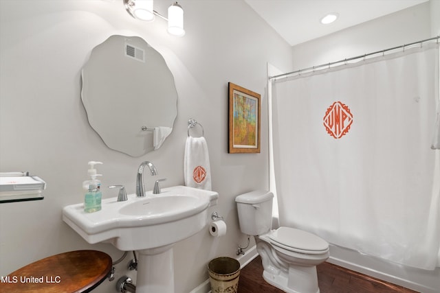 bathroom featuring toilet, shower / bath combo with shower curtain, and hardwood / wood-style floors