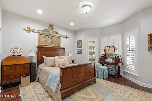 bedroom featuring baseboards, wood finished floors, and recessed lighting