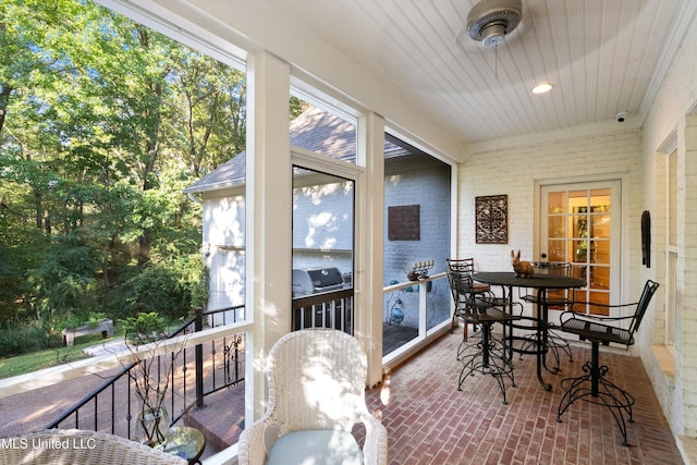 sunroom with outdoor dining space and a healthy amount of sunlight