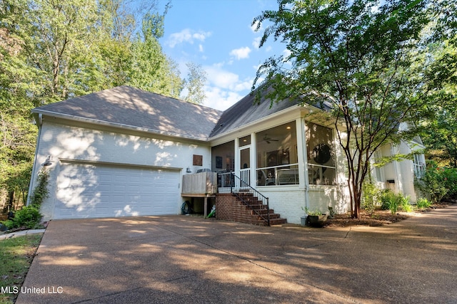 single story home featuring a ceiling fan, a shingled roof, driveway, brick siding, and a garage