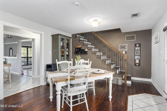 dining space featuring a textured ceiling and hardwood / wood-style floors