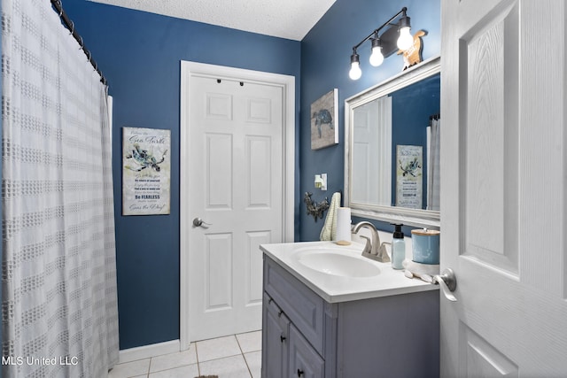 bathroom with vanity, a textured ceiling, and tile patterned floors