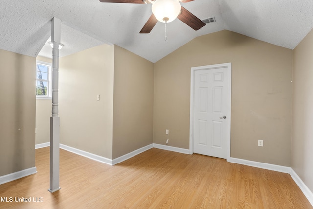 interior space featuring lofted ceiling, hardwood / wood-style floors, a textured ceiling, and ceiling fan