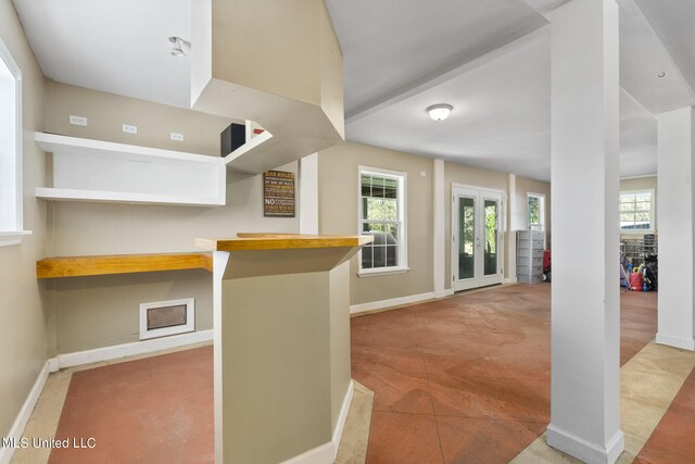 kitchen with tile patterned floors, a kitchen breakfast bar, kitchen peninsula, and plenty of natural light