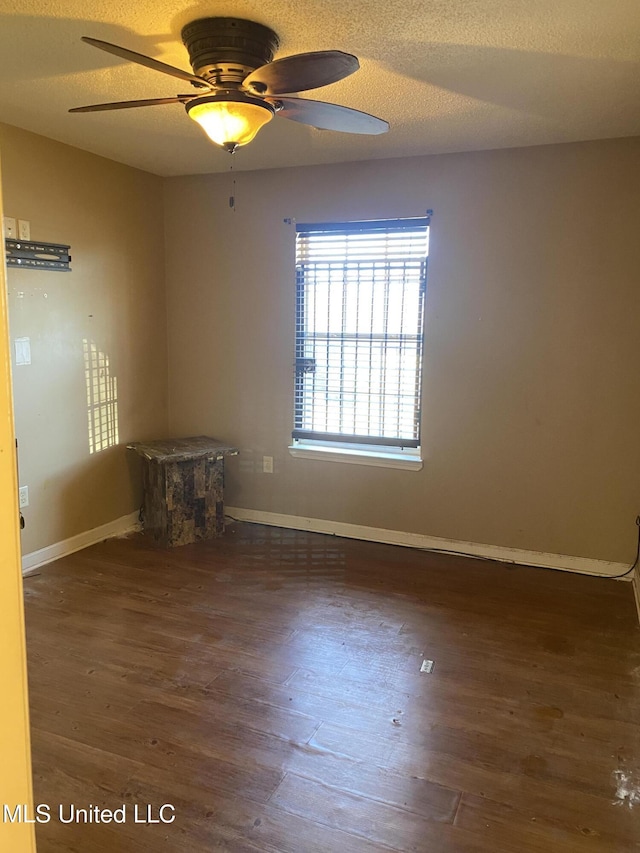 spare room featuring ceiling fan, a textured ceiling, and dark hardwood / wood-style floors