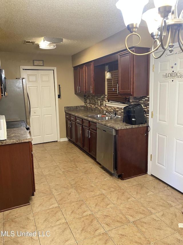 kitchen featuring a textured ceiling, a chandelier, tasteful backsplash, appliances with stainless steel finishes, and sink