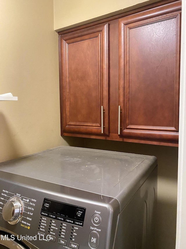 laundry area featuring separate washer and dryer and cabinets