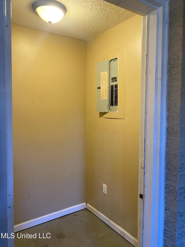 interior space with a textured ceiling and electric panel