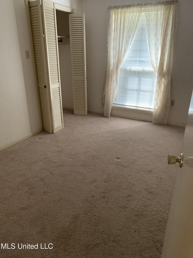 unfurnished bedroom with carpet and a closet