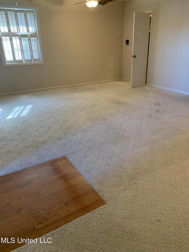 carpeted spare room featuring ceiling fan