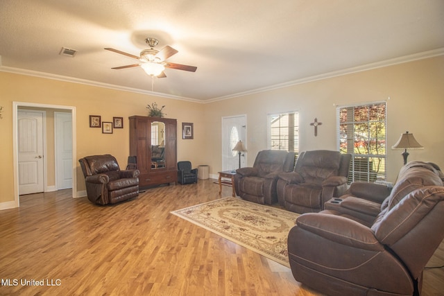 living room featuring ceiling fan, ornamental molding, and light wood-type flooring