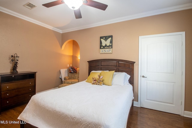 bedroom with dark hardwood / wood-style flooring, ceiling fan, and crown molding