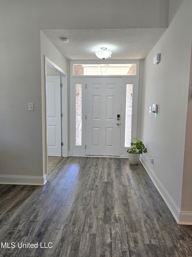 entryway featuring dark hardwood / wood-style floors and a textured ceiling