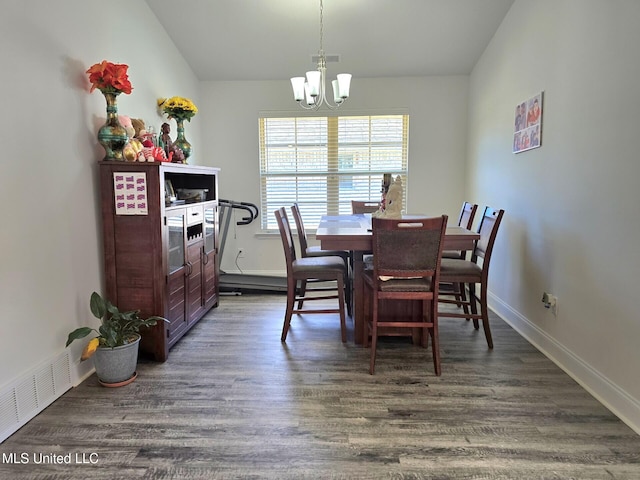 dining area featuring dark hardwood / wood-style floors, vaulted ceiling, and a chandelier