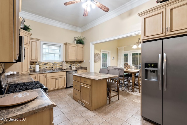 kitchen featuring appliances with stainless steel finishes, tasteful backsplash, a center island, and light tile patterned floors