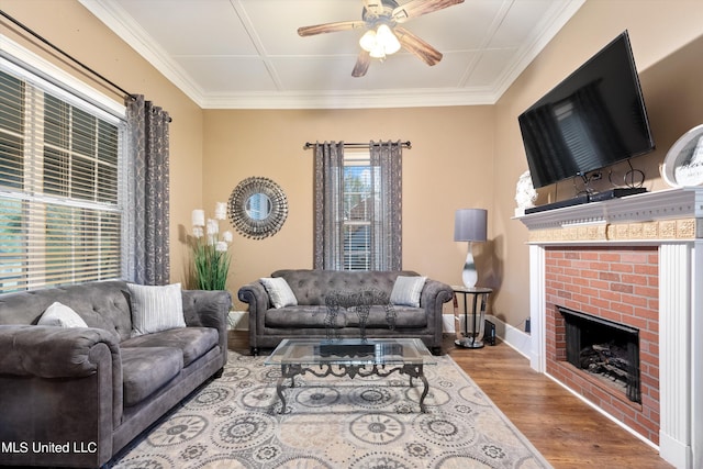 living room featuring ceiling fan, wood-type flooring, ornamental molding, and a fireplace