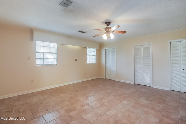 unfurnished bedroom with multiple closets, ornamental molding, a textured ceiling, and ceiling fan