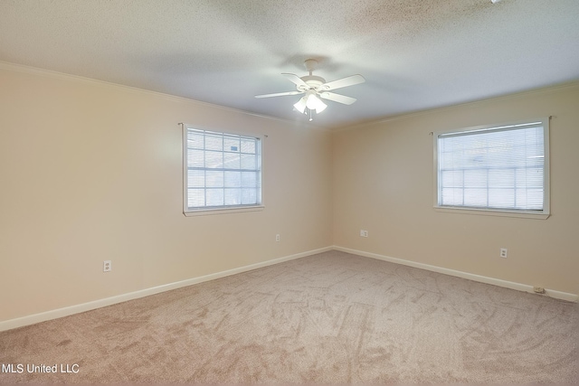 carpeted empty room with ceiling fan, ornamental molding, and a textured ceiling