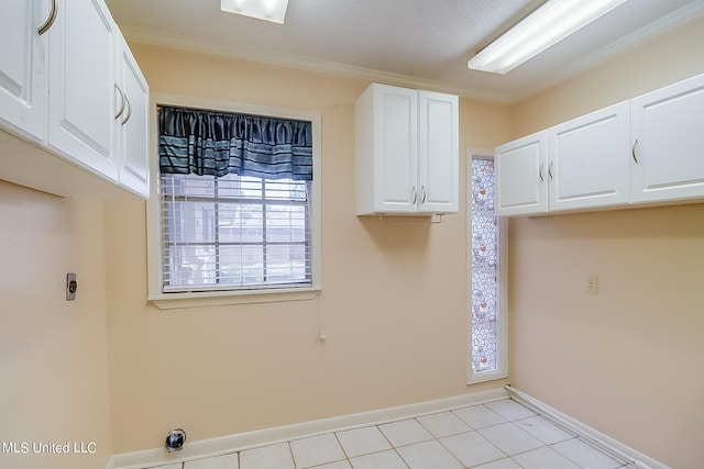 washroom featuring cabinets, hookup for an electric dryer, and light tile patterned flooring