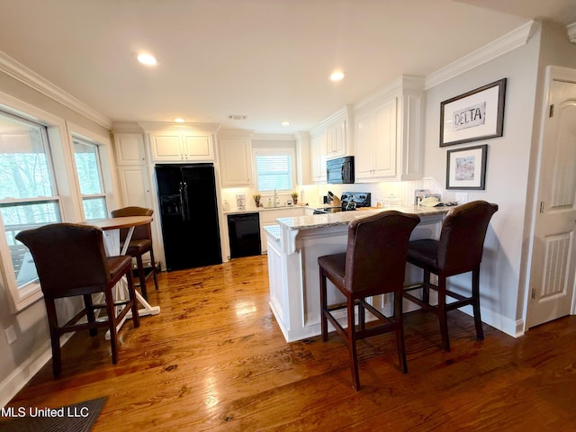 2997 Deerfield Rd, Yazoo City, MS 39194 - kitchen with black appliances, a sink, a peninsula, white cabinetry, and ornamental molding