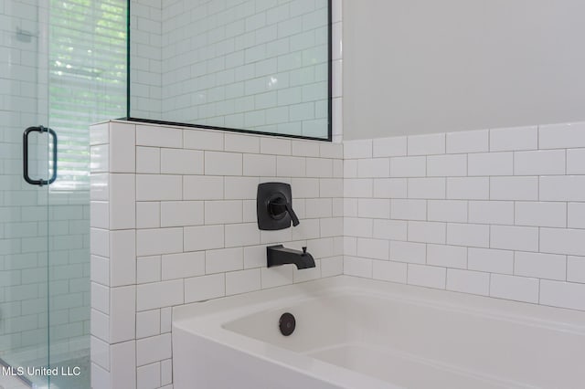 bathroom featuring a stall shower and a bathtub