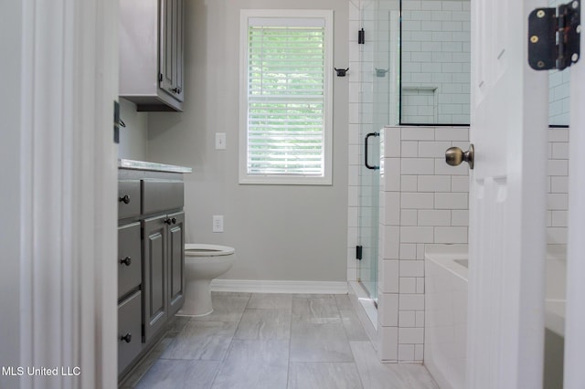 bathroom featuring toilet, a stall shower, vanity, a tub, and baseboards