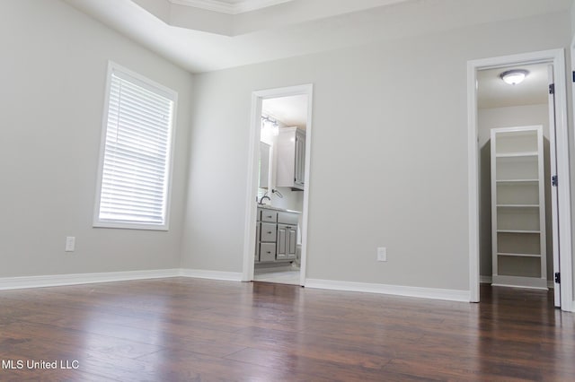 spare room with dark wood-style flooring and baseboards
