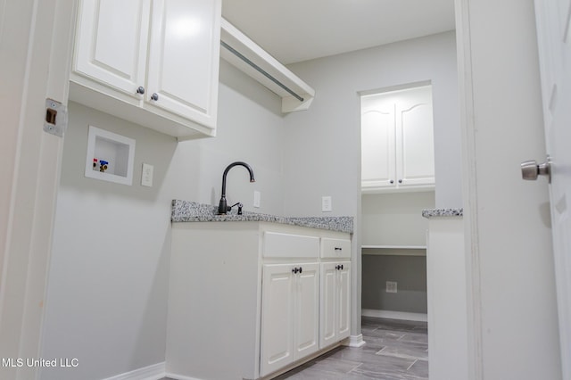 laundry room featuring cabinet space, hookup for a washing machine, and baseboards