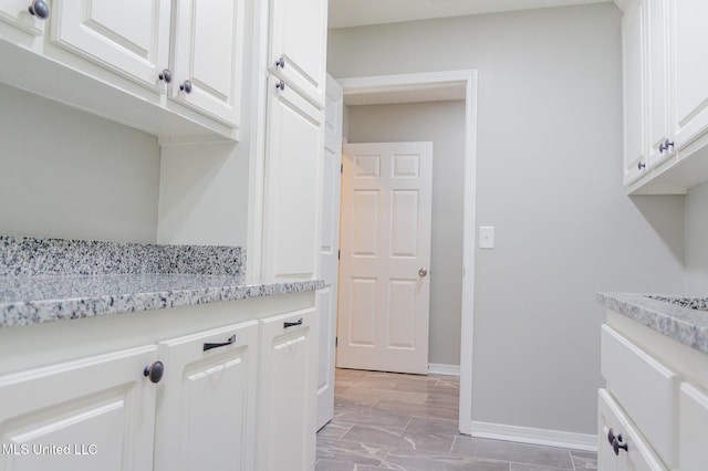 clothes washing area with baseboards