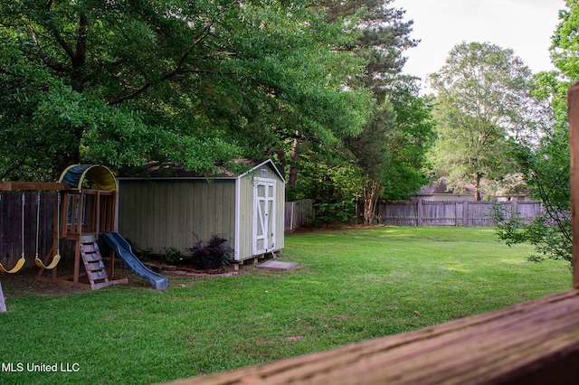 view of yard with a storage unit, a playground, and an outbuilding