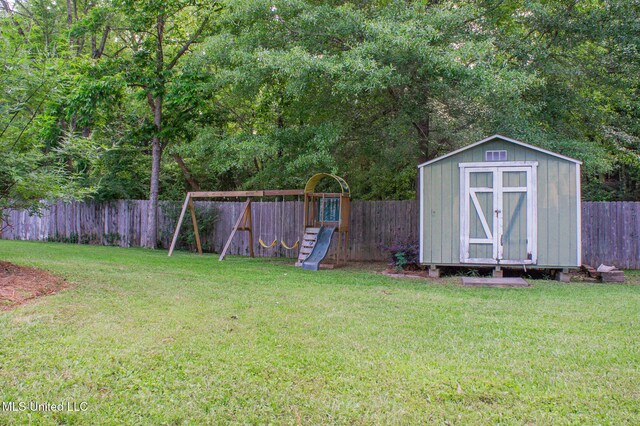 view of yard featuring a playground, a shed, and an outbuilding